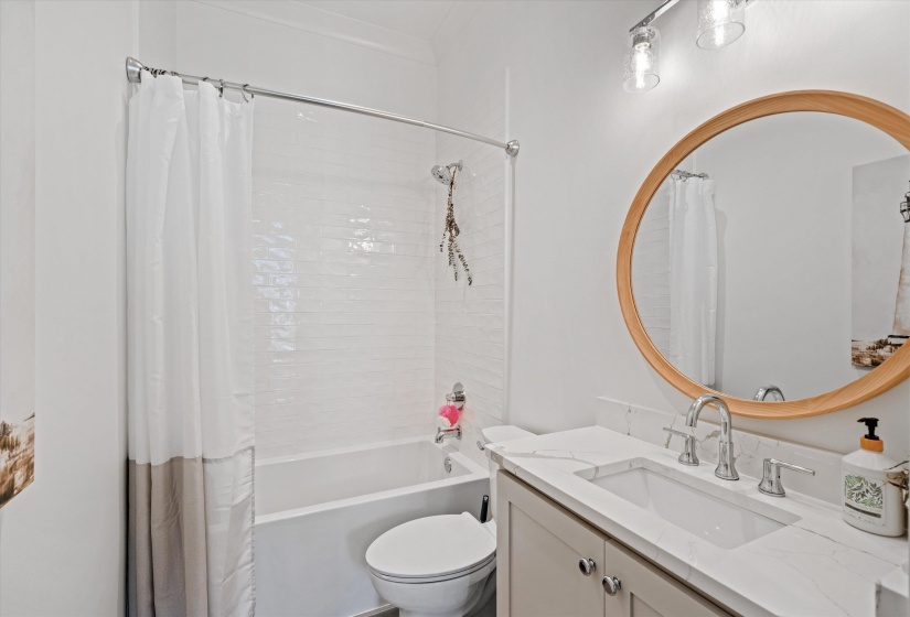 Private bathroom for downstairs bedroom with shower / tub combo with curtain and vanity