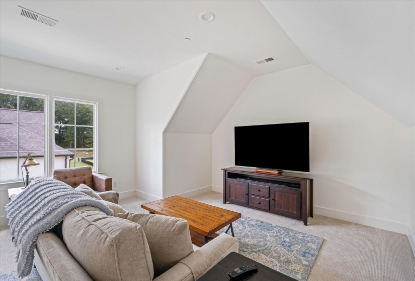 Bonus room with light carpet, lofted ceiling, and recessed lighting