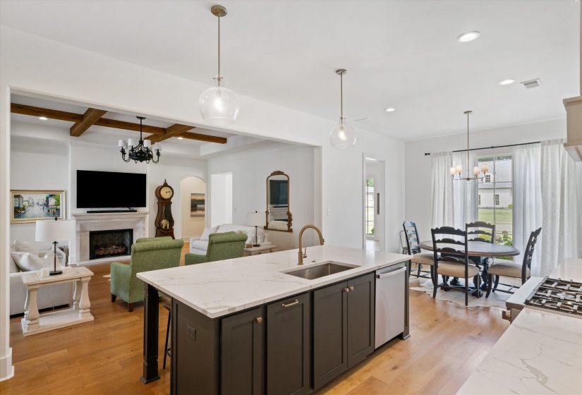 Kitchen with a chandelier, light stone counters, decorative light fixtures, a fireplace, and recessed lighting