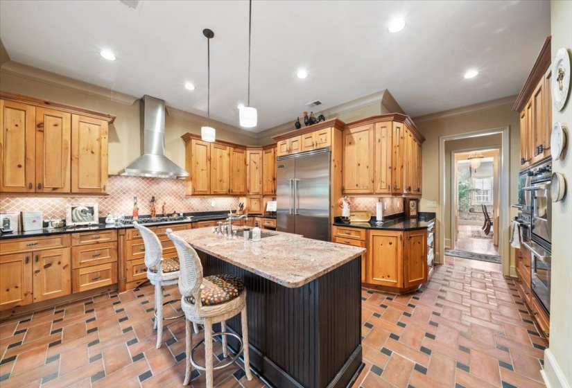 Kitchen with decorative backsplash, dark stone counters, decorative light fixtures, appliances with stainless steel finishes, and recessed lighting