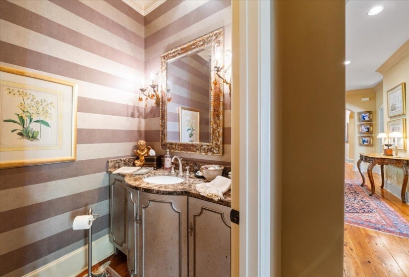 Bathroom with wallpapered walls, crown molding, vanity, and light wood-type flooring