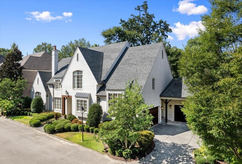 View of front facade featuring a garage, concrete driveway, and a chimney