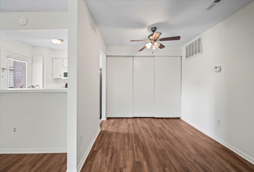 Unfurnished living room with dark wood finished floors, a textured ceiling, and ceiling fan