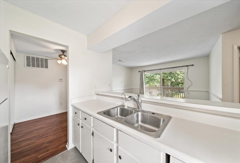 Kitchen with white cabinetry, light countertops, dark wood-style floors, and a textured ceiling