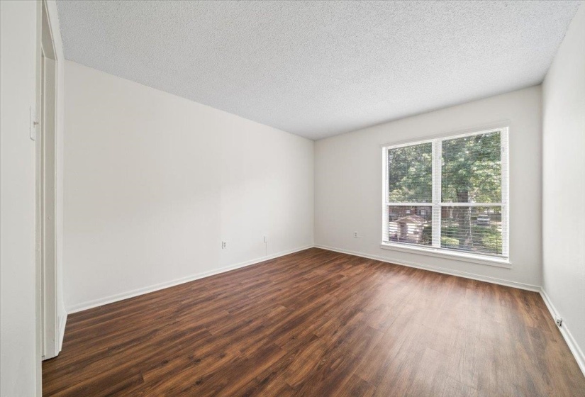 Spare room with dark wood-style floors and a textured ceiling