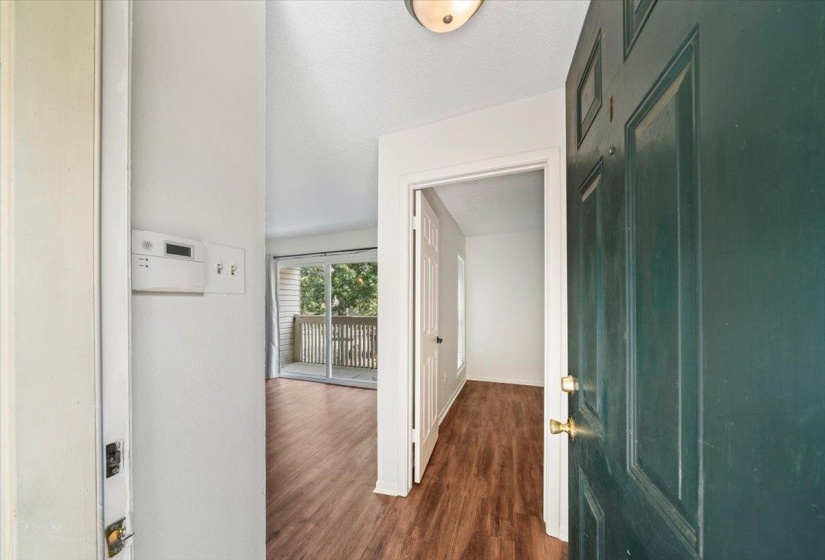 Hallway featuring dark wood-style flooring and a textured ceiling