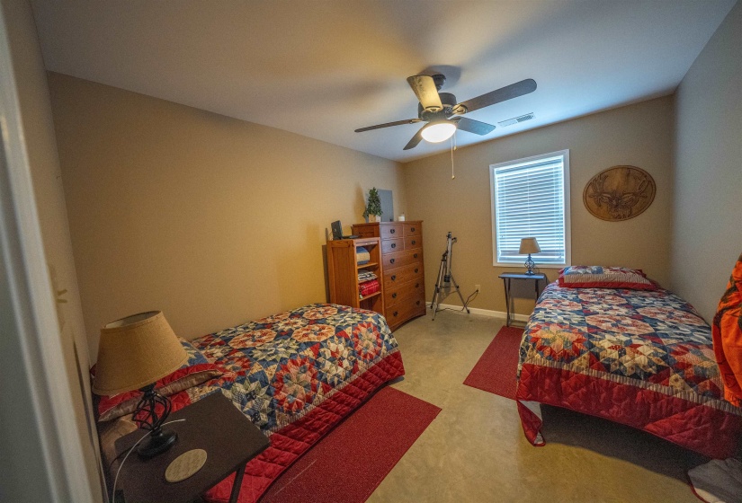 Bedroom with light carpet and a ceiling fan