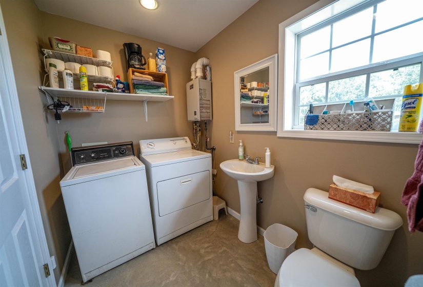 Laundry room featuring washer and dryer and tankless water heater