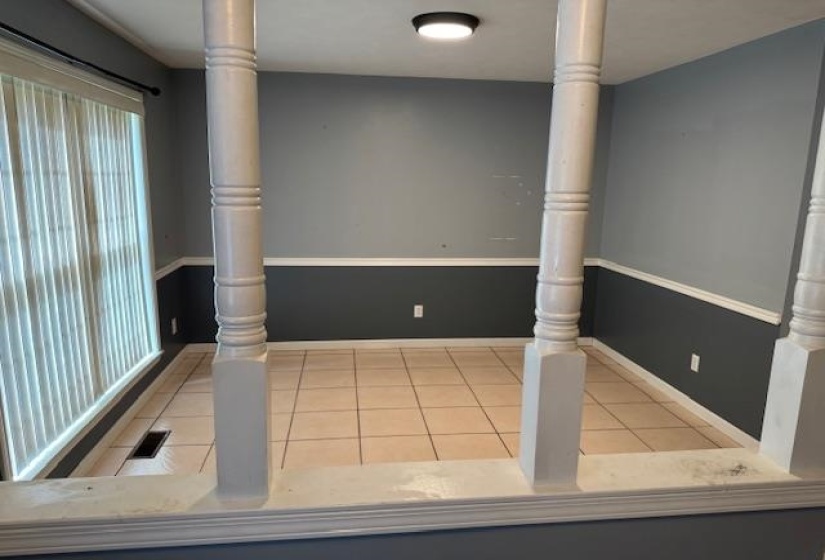 Room with tile flooring, gray and dark gray two-tone walls, and white trim
