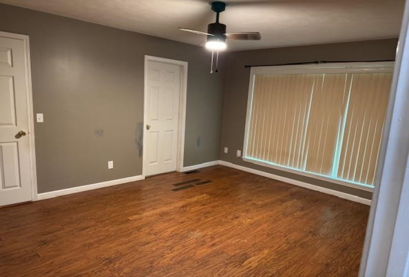 Room featuring wood-finish flooring, neutral wall color, and white trim
