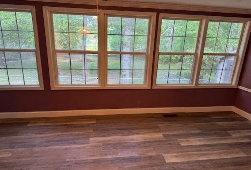 Expansive windows with grid detailing frame a wooded exterior