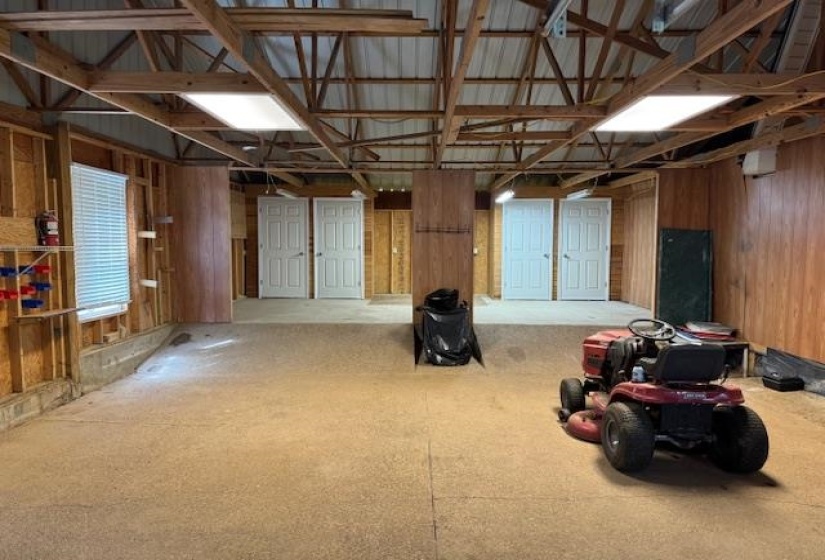 Spacious unfinished interior area featuring exposed wood framing, metal ceiling, and two recessed ceiling lights