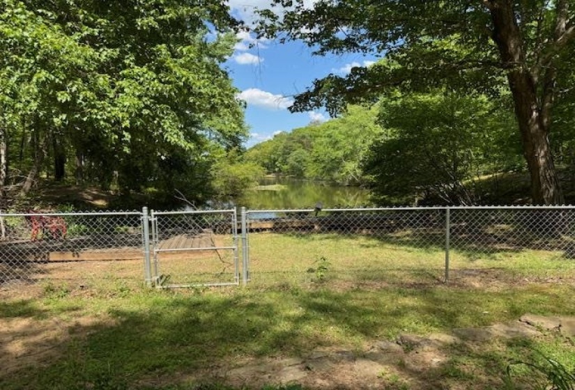 Wooded waterfront lot with chain-link fencing