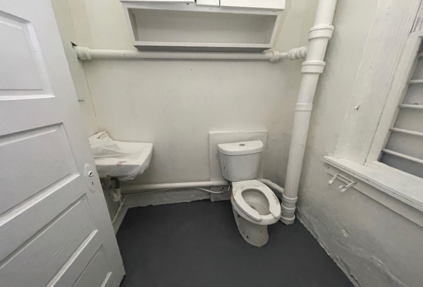 Bathroom featuring toilet and concrete flooring