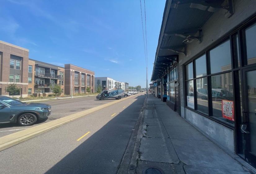 View of asphalt street featuring sidewalks and curbs