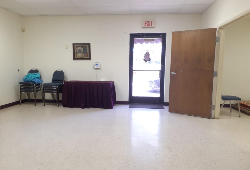 Foyer entrance featuring a drop ceiling and baseboards