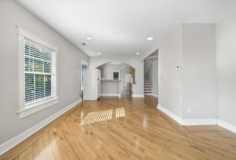 Unfurnished living room featuring stairs, recessed lighting, light wood-style flooring, and arched walkways