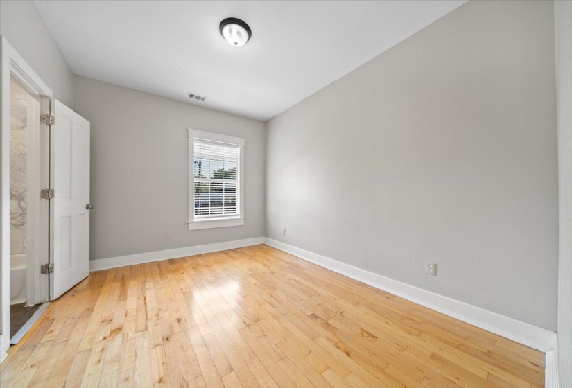Unfurnished bedroom with light wood finished floors and baseboards
