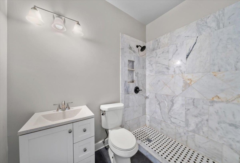 Full bath with vanity and a tile shower