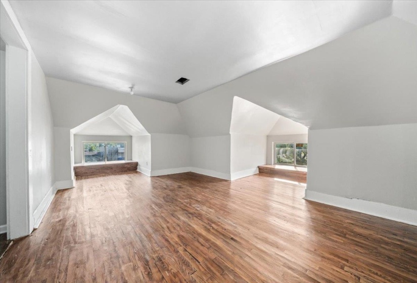 Bonus room featuring vaulted ceiling, dark wood finished floors, and plenty of natural light