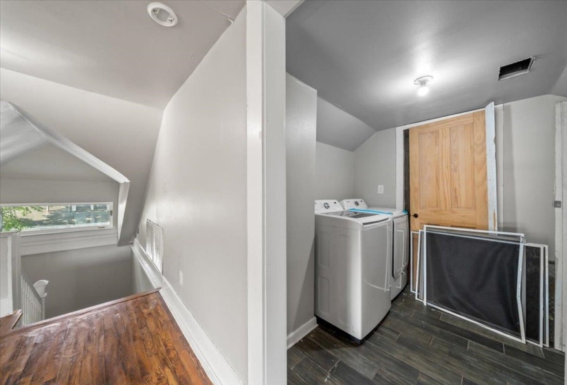 Laundry room featuring dark wood-style flooring and washer and clothes dryer
