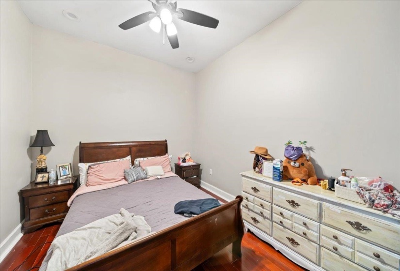 Bedroom featuring dark wood-style floors, vaulted ceiling, and a ceiling fan