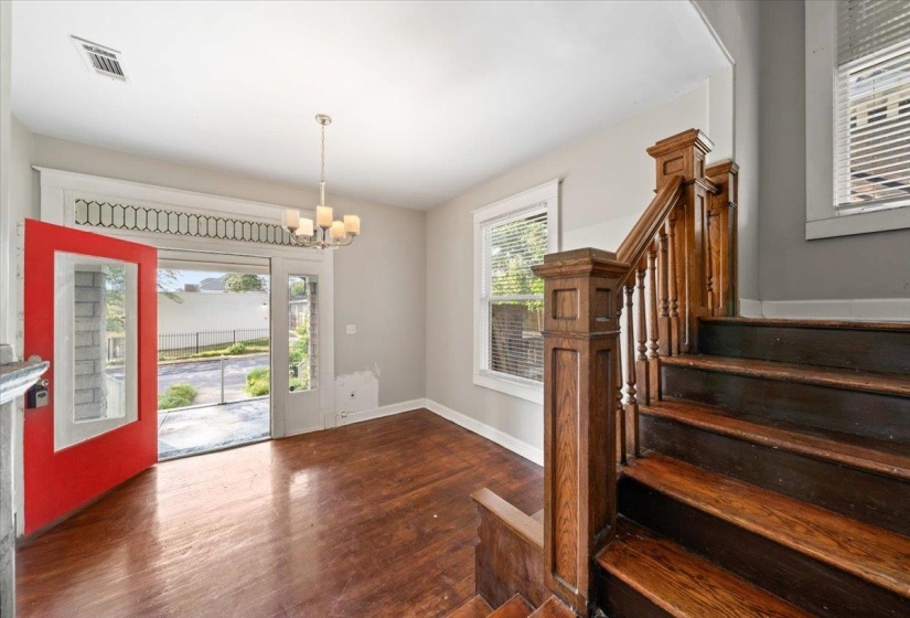 Foyer with plenty of natural light, dark wood-style floors, stairs, and a chandelier