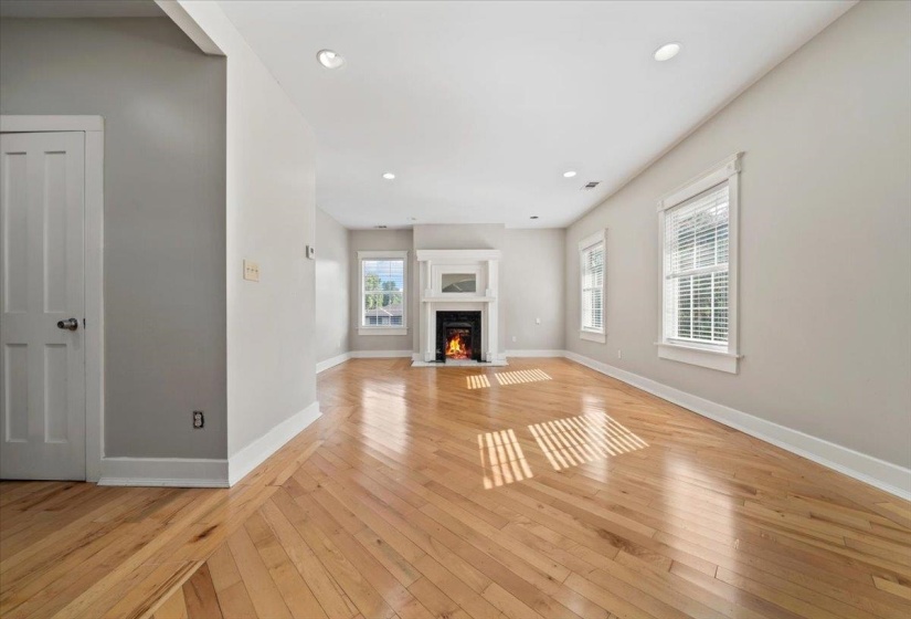 Unfurnished living room with recessed lighting, light wood-style floors, and a fireplace with flush hearth