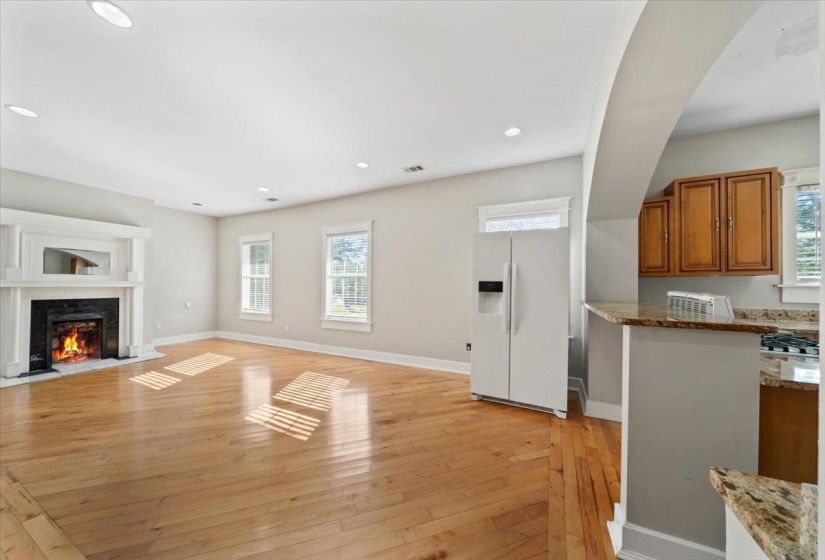 Unfurnished living room featuring plenty of natural light, light wood-type flooring, a fireplace with flush hearth, and recessed lighting