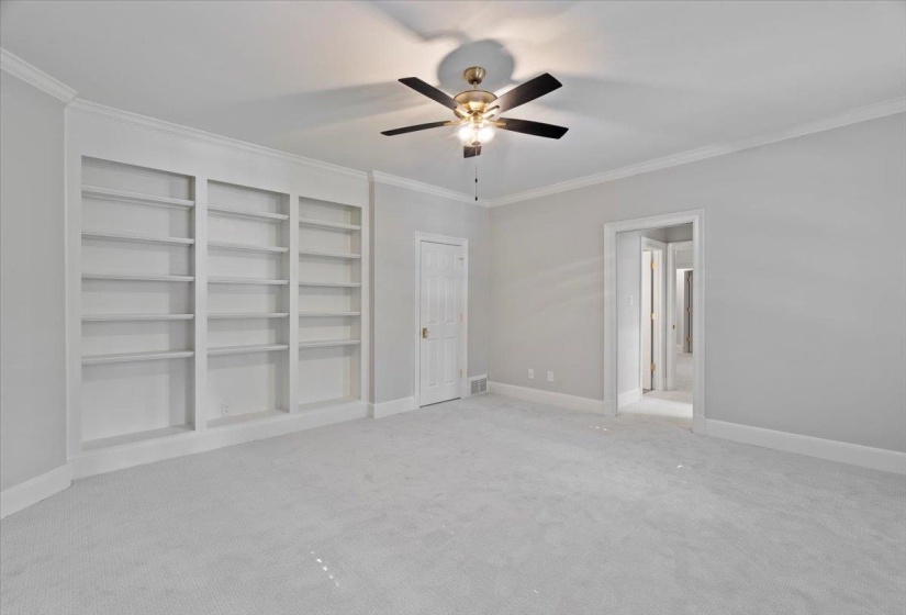 Unfurnished bedroom with crown molding, light colored carpet, and ceiling fan