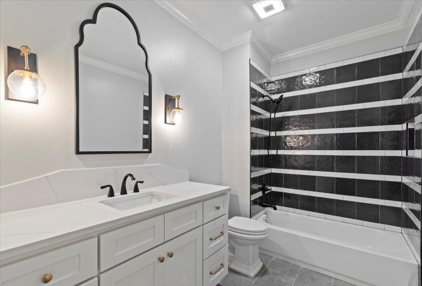 Full bath featuring shower / bathtub combination, vanity, ornamental molding, and tile patterned floors