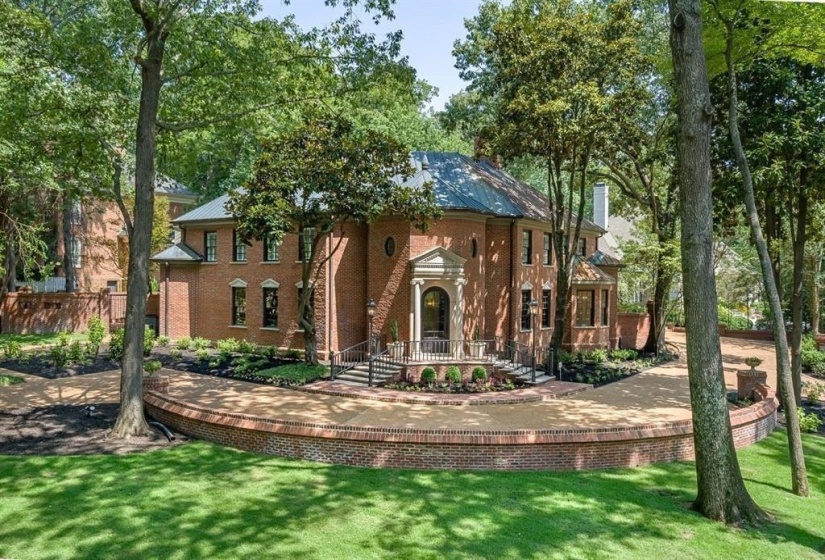 View of front of home with a front yard, brick siding, and a metal roof