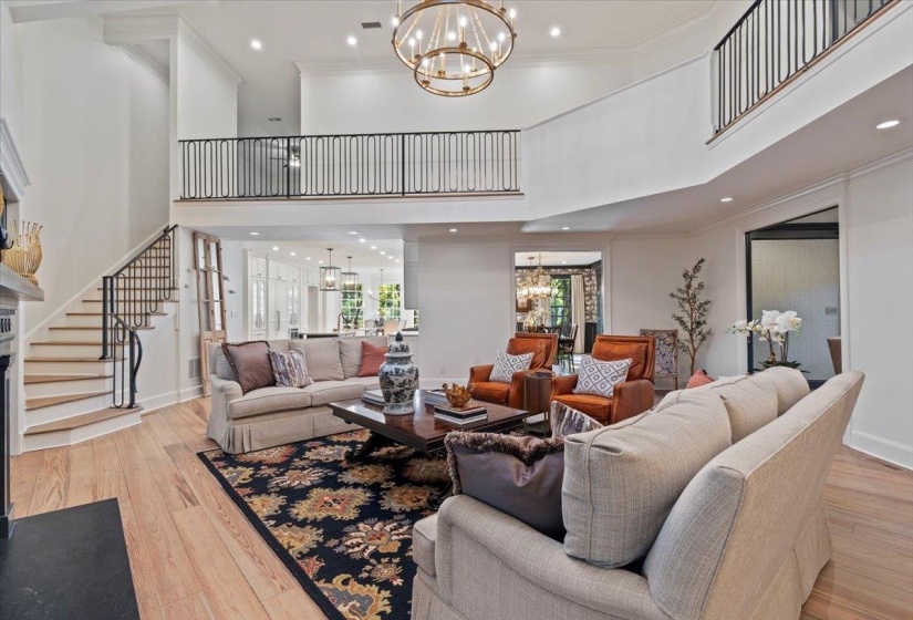 Living area featuring a chandelier, ornamental molding, recessed lighting, stairway, and light wood-style floors