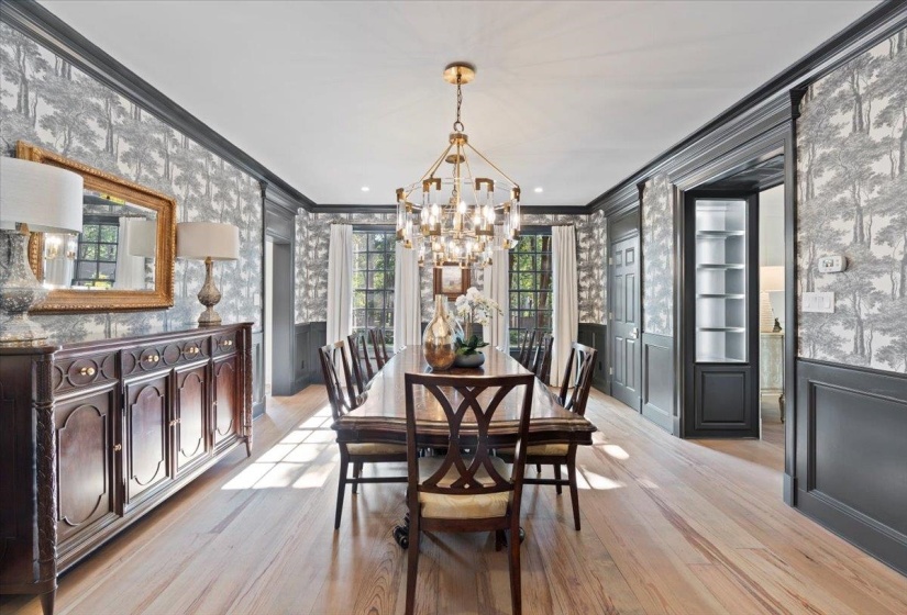 Dining room featuring crown molding, wallpapered walls, light wood finished floors, and a chandelier