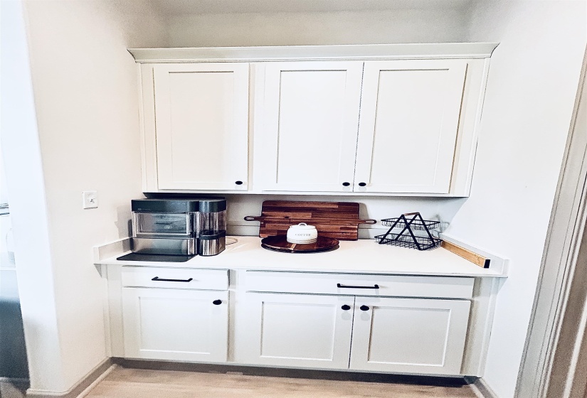 Bar area with white cabinetry