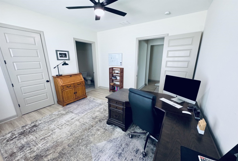 Home office featuring light wood-style flooring and a ceiling fan