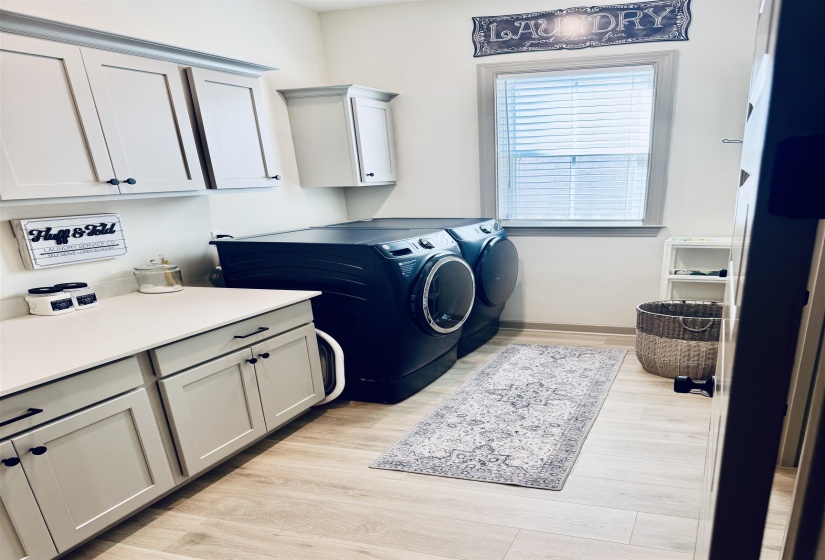Laundry room featuring light wood-style floors, independent washer and dryer, and cabinet space