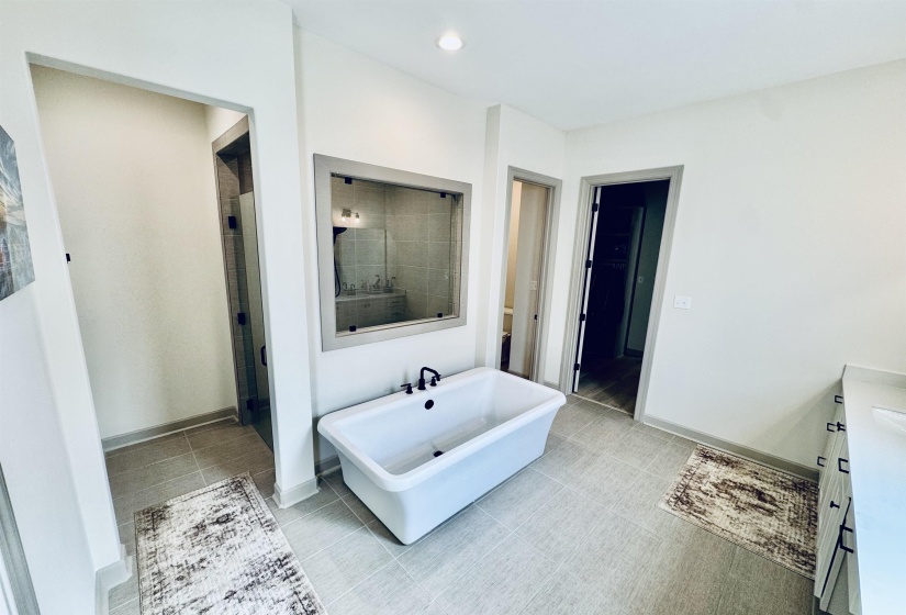 Full bath featuring vanity, a soaking tub, light tile patterned floors, and recessed lighting