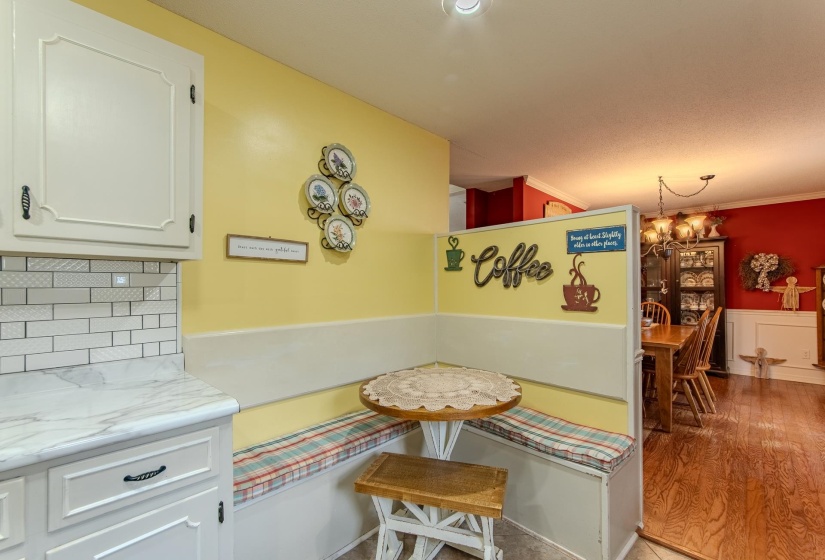 Dining space with wainscoting, light wood finished floors, crown molding, and a chandelier