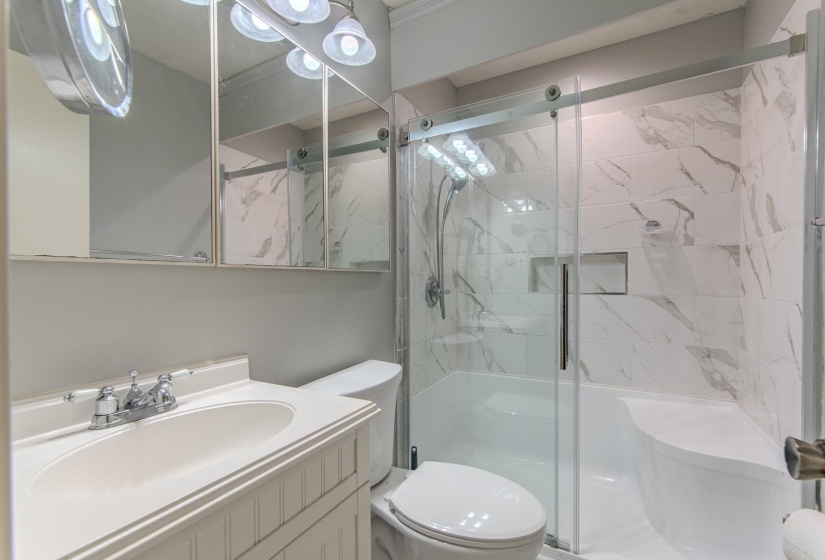 Full bath with a shower stall and vanity