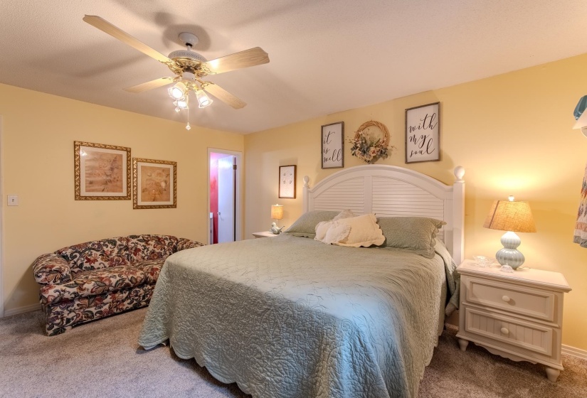 Carpeted bedroom featuring ceiling fan and baseboards