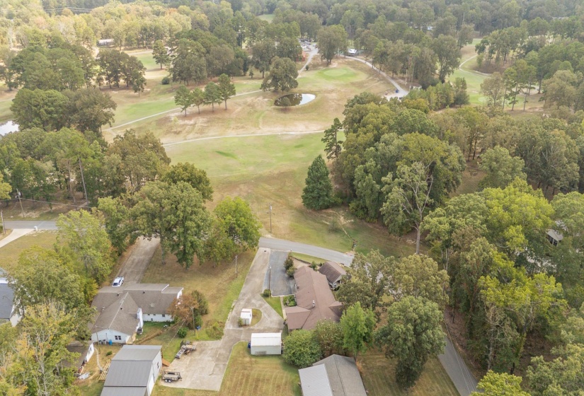 Aerial overview of property's location with a golf course and nearby suburban area