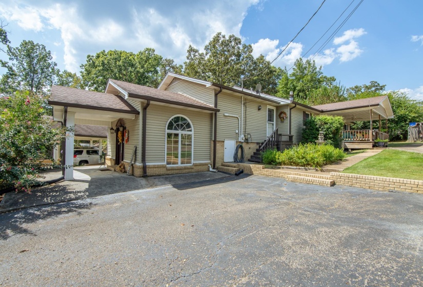 View of front of house featuring asphalt driveway, an attached carport, and roof with shingles