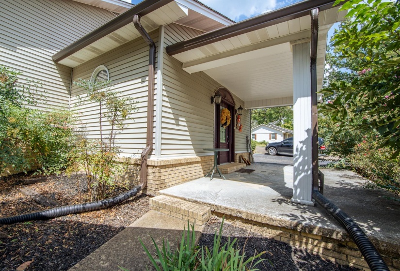 Doorway to property featuring covered porch and an attached carport