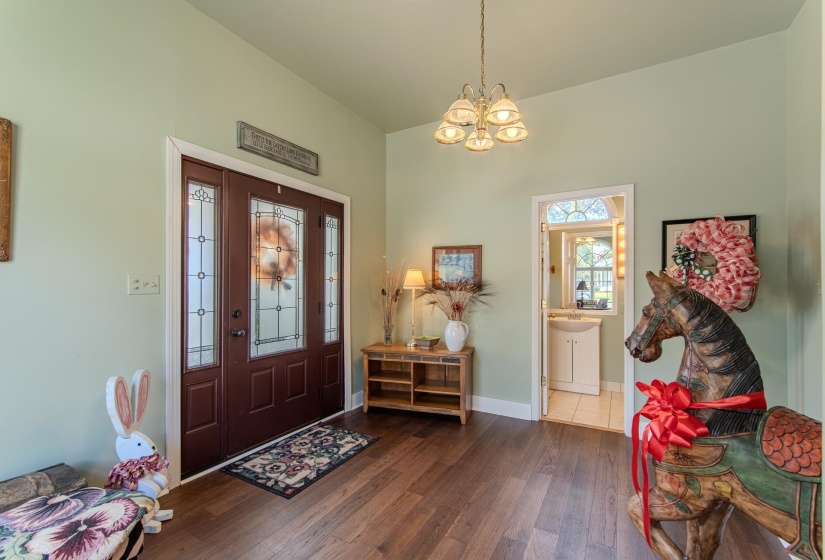 Foyer entrance featuring dark wood finished floors and a chandelier