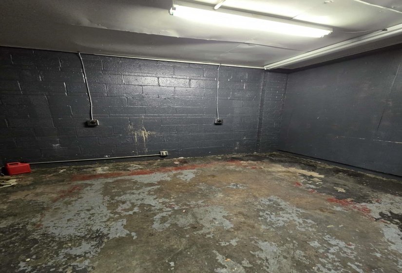 Spare room featuring concrete block wall and concrete flooring