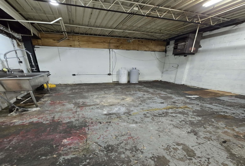 Below grade area featuring a heating unit, concrete block wall