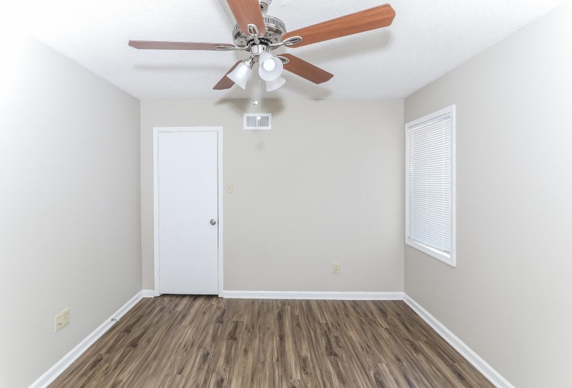 Spare room featuring dark wood-type flooring and ceiling fan