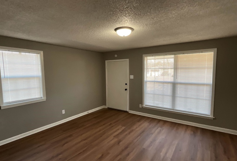Foyer entrance featuring a textured ceiling and dark hardwood / wood-style flooring