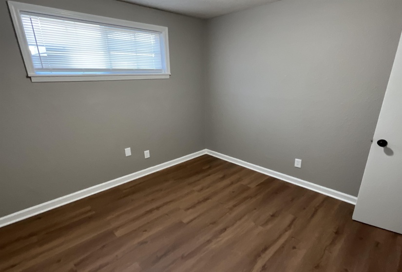 Unfurnished room with dark wood-type flooring